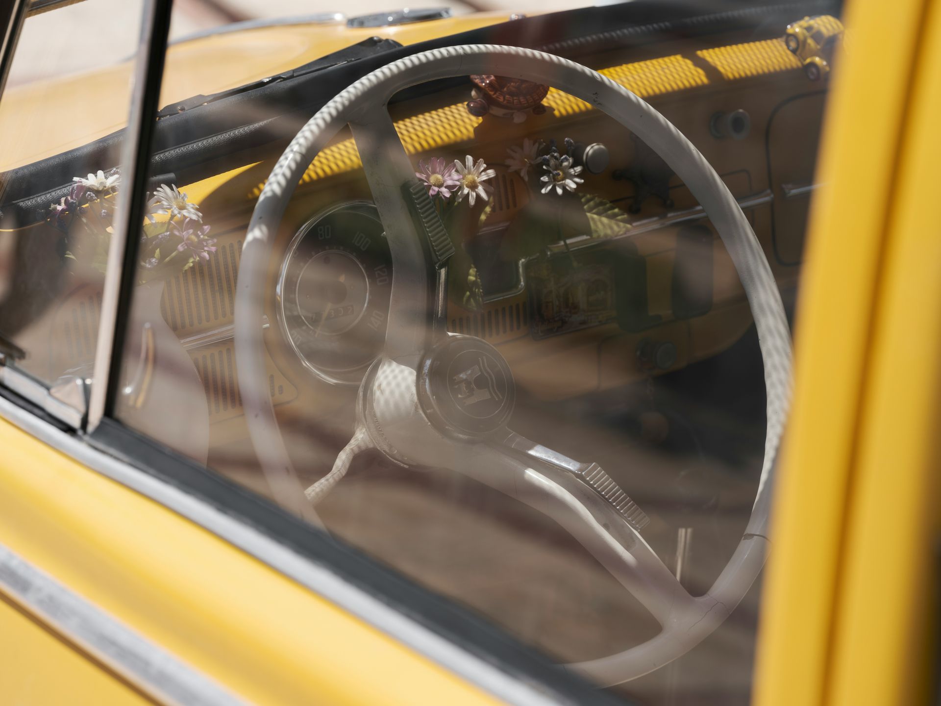 A close up of a yellow car with a steering wheel